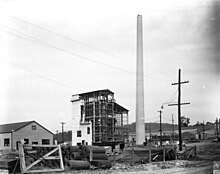 Building site. A chimney has been erected and scaffolding has gone up.