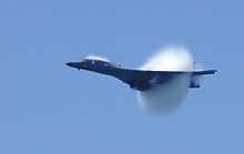 A B-1B makes a high-speed, transonic pass, with the aircraft passing through a shock wave during the Pensacola Beach air show in 2003