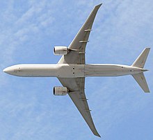 Aircraft in flight, underside view. The jet's two wings have one engine each. The rounded nose leads to a straight body section, which tapers at the tail section with its two rear fins.