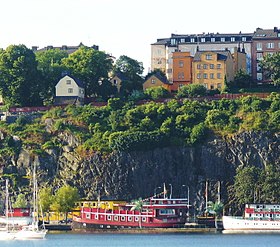 Parti av Mariaberget, kritteckning av Gustaf Isander 1912 och samma parti år 2012. Det ljusputsade huset till vänster är Blecktornsgränd 1 och byggnaderna till höger därom hör till kvarteret Kattörat.