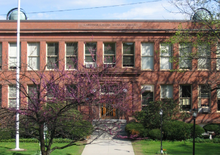 Red-two-story building with spring-flowering tree in front