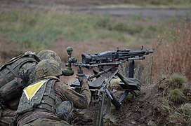 MG3 auf Dreibein mit Winkelzielfernrohr, zusätzlich mit Schultergurten und Polster zum Transport auf dem Rücken