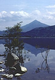 Ein symmetrischer Berg spiegelt sich im Wasser eines Sees.