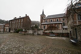 Village. In the foreground, a square. In the background on the left, buildings and on the right, a religious building.