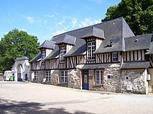 Photo d'une maison construite en pierre et en bois avec un toit en ardoise.