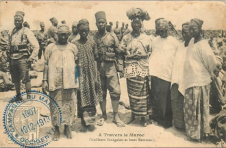 Photo d'un militaire africain au milieu de plusieurs femmes, avec plusieurs militaires africains derrière eux