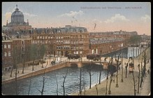 De brug in 1920, met links de hoge koepel van het voormalige Paleis van Volksvlijt