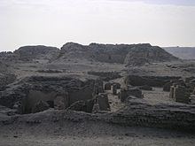 A maze of low walls and ruins in the desert.