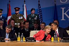 Obama whispering to Clinton at a summit meeting