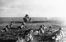 Japanese soldiers creeping in front of wrecked Soviet tanks.jpg