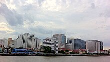 Large modern buildings, seen from a distance over water