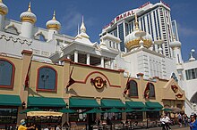 The façade of the Trump Taj Mahal, a casino in Atlantic City. It has motifs evocative of the Taj Mahal in India. A tall building with the resort's name stands in the background.