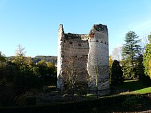 Photo représentant la tour de Vésone, une haute et large tour circulaire en briques située au milieu d'un parc arboré. Sur la gauche, une brèche très importante court de haut en bas de l'édifice, montrant l'intérieur.