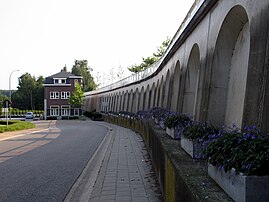 Illustratie van de grondverzakking als gevolg van de steenkoolontginning. Dit huis in Eisden-Dorp lag ooit op hetzelfde niveau als de reling.