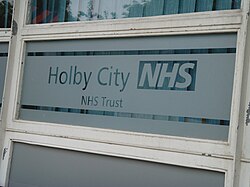 A partially frosted window which reads 'Holby City NHS, NHS Trust'