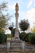 Une statue de la Vierge posée en haut d'une colonne sculptée