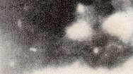 An enlargement of the Moorman photograph: the figure of a man can be hazily seen. He appears to be firing a gun, with bright muzzle flare obscuring his right side. He may be wearing a dark uniform, with a white object on his left chest.