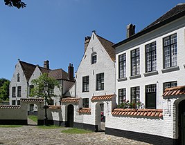 Maisons no 16 (à droite, millésimé 1854 en façade), no 18 (au centre, XVIe et XVIIe siècles) et no 20 (double pignon de gauche, également des XVIe et XVIIe). Le mur de séparation entre jardinets des maisons et enclos central est bien visible.