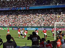 A soccer game between the United States and Canada, seen from behind one of the goals