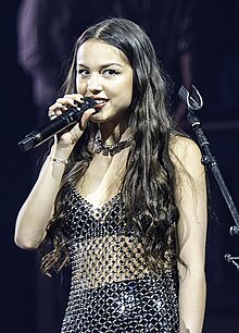 Olivia Rodrigo performing in a fishnet outfit