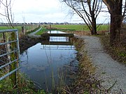 Een van de bruggen van het Zevenbruggetjespad gezien vanaf Ter Laan met Bedum op de achtergrond