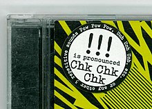 Fokus auf CD-Hülle links oben auf Aufkleber, das !!! als Chk Chk Chk ausgesprochen wird