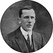 Gowers in suit and tie, sitting for a formal photograph