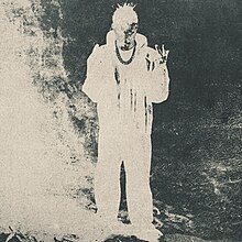 Cover art for Éxodo, which depicts a high-contrast inverted-color image of a man holding up the V sign with both of his hands.